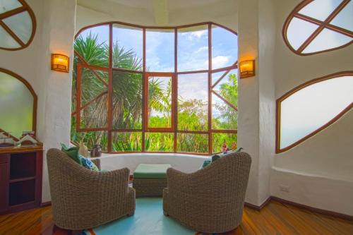 a living room with two chairs and a large window at Finca Rosa Blanca Coffee Farm and Inn in Heredia