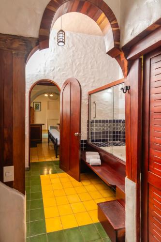 a room with a bathroom with a tub and a bedroom at Finca Rosa Blanca Coffee Farm and Inn in Heredia