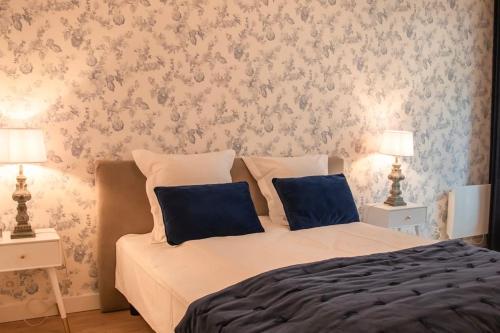- une chambre dotée d'un lit avec des oreillers bleus et du papier peint dans l'établissement Logement Centre Ville de Reims - Commerces - Wifi, à Reims