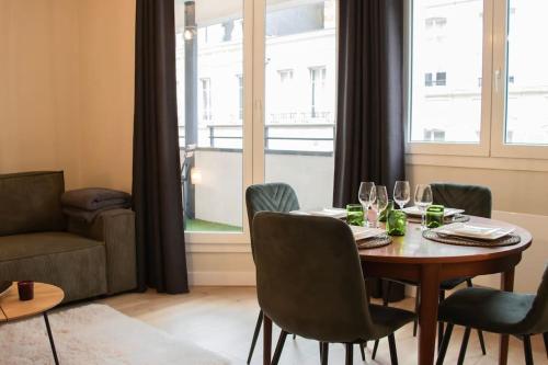 une salle à manger avec une table et des chaises et une fenêtre dans l'établissement Logement Centre Ville de Reims - Commerces - Wifi, à Reims