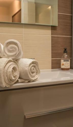 une pile de serviettes sur une étagère dans une salle de bain dans l'établissement Logement Centre Ville de Reims - Commerces - Wifi, à Reims