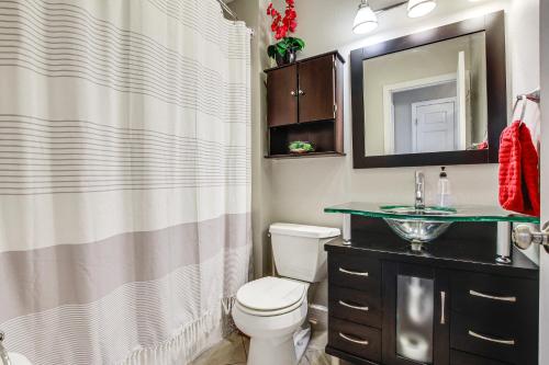 a bathroom with a toilet and a sink and a mirror at Oshkosh Canal-Front Home with Sunroom and Watercraft! in Oshkosh