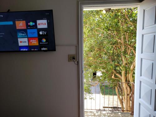 an open door with a television and a tree at Pousada Monte Gerizim in Sao Paulo
