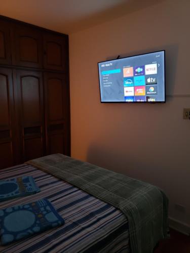 a room with a bed and a tv on the wall at Pousada Monte Gerizim in Sao Paulo