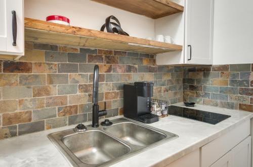 a kitchen with a sink and a microwave at Modern Greenwood Studio Less Than 1 Mi to Downtown! in Greenwood