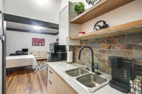 a kitchen with a sink and a living room at Modern Greenwood Studio Less Than 1 Mi to Downtown! in Greenwood