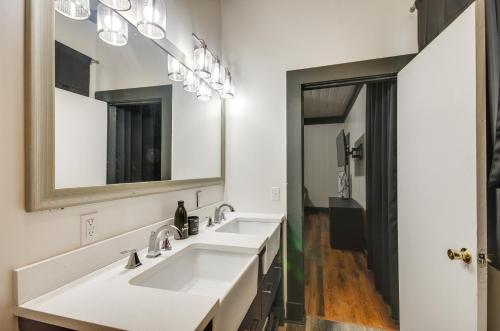 a bathroom with two sinks and a mirror at Modern Greenwood Studio Less Than 1 Mi to Downtown! in Greenwood
