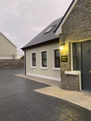 a brick house with a garage and a driveway at Killard House in Caherlean