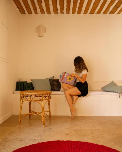 a woman sitting on a couch holding a present at Le Clos de Gordes in Gordes