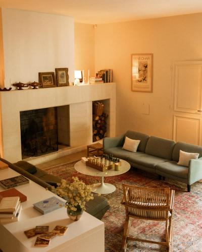 a living room with a couch and a fireplace at Le Clos de Gordes in Gordes