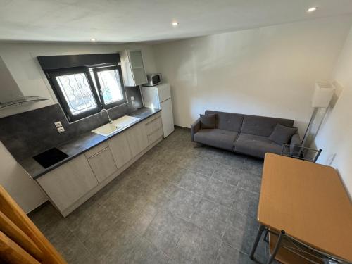 un salon avec un canapé et une cuisine dans l'établissement Appartement 2A, à Avignon