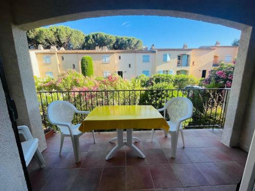 une table et des chaises jaunes sur un balcon dans l'établissement Grand studio à 5 min de la plage, à La Garonnette-Plage