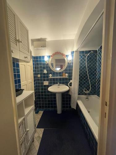 une salle de bain avec un lavabo, une baignoire et un miroir dans l'établissement Grand studio à 5 min de la plage, à La Garonnette-Plage