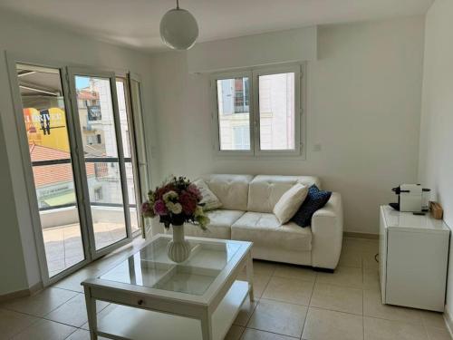 un salon avec un canapé blanc et une table dans l'établissement Magnifique T2 Cannes Centre, à Cannes