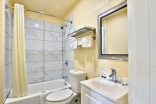 a bathroom with a sink and a toilet and a mirror at Americas Best Value Inn San Antonio Airport South in San Antonio