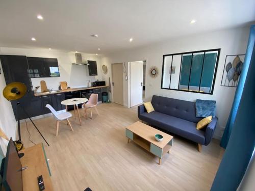 a living room with a blue couch and a table at T2 spacieux avec baignoire Balnéo en RdC sur cour in Saint-Florentin