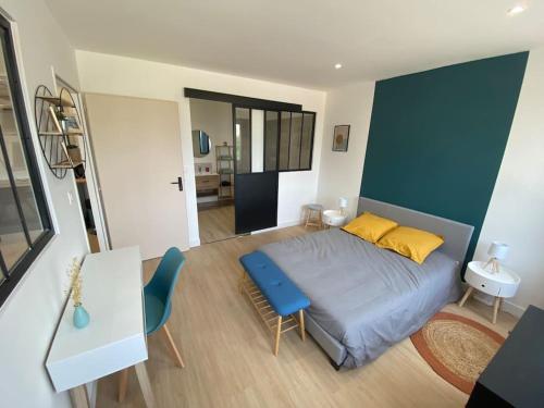 a bedroom with a bed and a blue wall at T2 spacieux avec baignoire Balnéo en RdC sur cour in Saint-Florentin