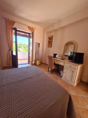 a bedroom with a bed and a desk with a window at Affittacamere A f r o d i t e in Lipari