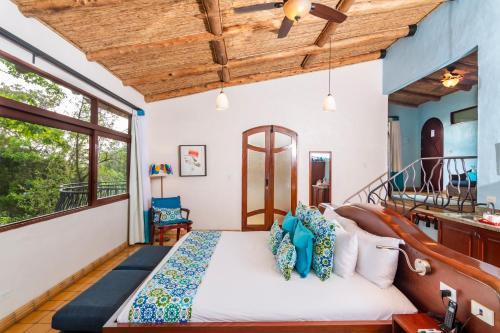 a bedroom with a large bed with blue pillows at Finca Rosa Blanca Coffee Farm and Inn in Heredia