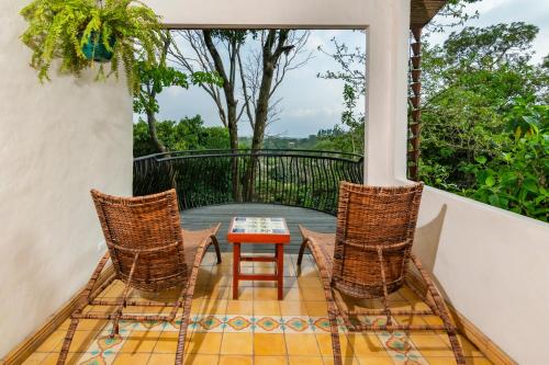 a patio with a table and chairs on a balcony at Finca Rosa Blanca Coffee Farm and Inn in Heredia