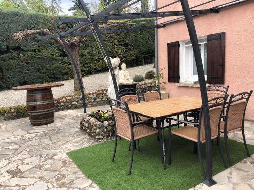 a wooden table and chairs on a patio at Chambres d'hôtes Marylou in Valensole