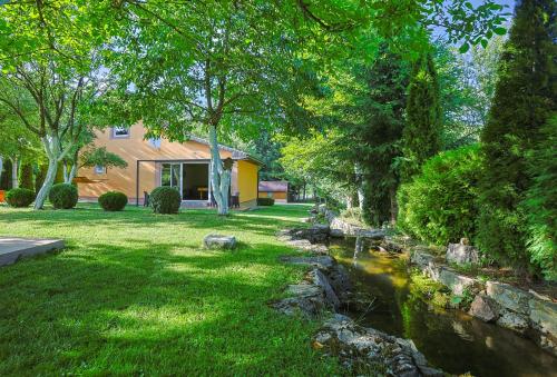 a yard with a stream in front of a house at Vita Verde Guest House - Pljevlja in Grevo