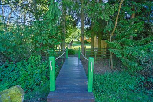 a wooden path in a park with green posts at Vita Verde Guest House - Pljevlja in Grevo