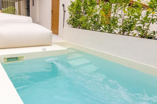 a swimming pool with blue water in a room at ADORNO PRIVATE SUITES Only Adults & Kids 12 Plus in Nea Vrasna