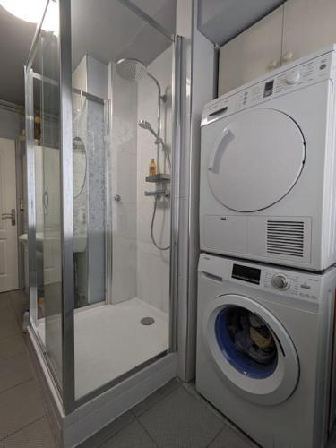 une salle de bain avec douche et machine à laver dans l'établissement Lumineux logement T4 proche bois Vincennes, à Vincennes