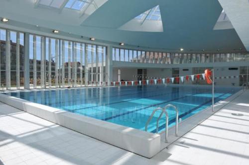 une grande piscine dans un grand bâtiment dans l'établissement Lumineux logement T4 proche bois Vincennes, à Vincennes
