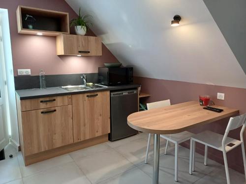 - une cuisine avec une table en bois et un évier dans l'établissement Studio Indépendant dans Demeure Typique d'Exception, à Saint-Vincent