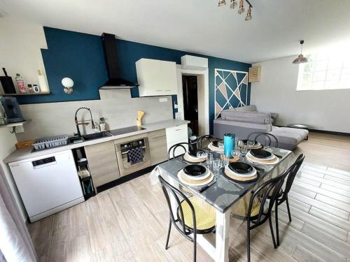 eine Küche mit Tisch und Stühlen in einem Zimmer in der Unterkunft Le Caladou ! T3 classé 3 étoiles - Centre ville in Espalion