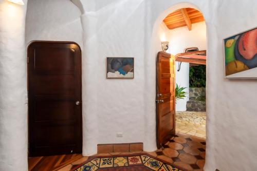 a hallway with a door and a painting on the wall at Finca Rosa Blanca Coffee Farm and Inn in Heredia