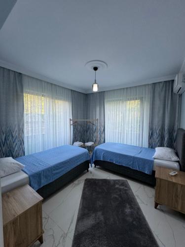 a bedroom with two beds and two windows at Sapanca Villa Dereiçi in Sapanca