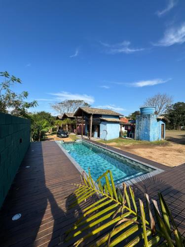 a swimming pool in front of a house at Rosatrip Surf Bungalows in Praia do Rosa