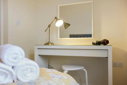 a bedroom with a table and a mirror and a chair at Riverside Townhouse Antrim in Antrim