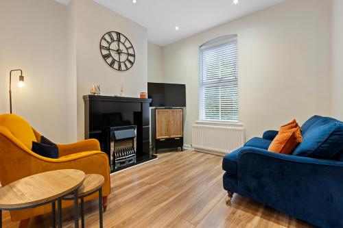a living room with a blue couch and a fireplace at Riverside Townhouse Antrim in Antrim