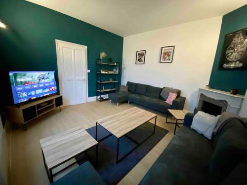 un salon avec un canapé et une télévision dans l'établissement Grande Maison de ville idéale pour se réunir, à Saint-Florentin