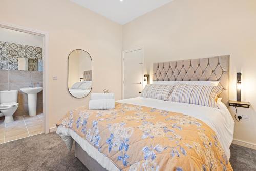 a bedroom with a large bed and a bathroom at Riverside Townhouse Antrim in Antrim