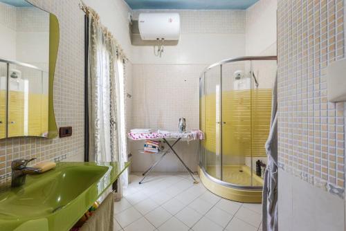 y baño con lavabo verde y ducha. en The Antique Villa by PS, en Golem