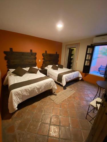 a bedroom with two beds and a large window at Hotel Boutique Tierra Magica in Tequila