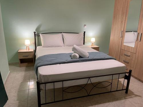 a bed in a room with two lamps on two tables at Blu Bene apartment in Mavrovouni, Gytheio in Mavrovoúnion
