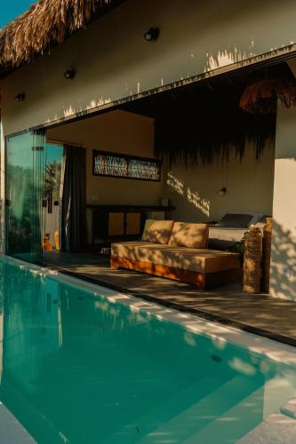 a swimming pool with a couch next to a house at Pousada Casa Buriti - Atins in Atins