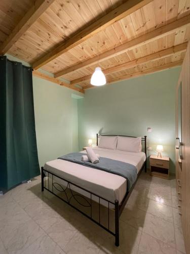 a bedroom with a large bed with a wooden ceiling at Blu Bene apartment in Mavrovouni, Gytheio in Mavrovoúnion
