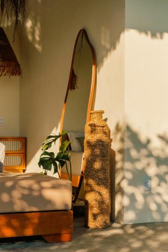 a bedroom with a mirror and a bed and a chair at Pousada Casa Buriti - Atins in Atins