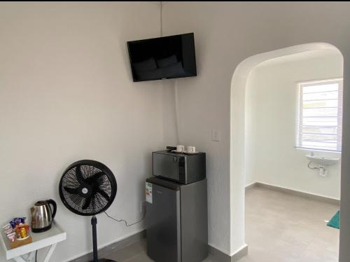 a room with a fan and a tv on the wall at No 1 Guest house in Cape Town
