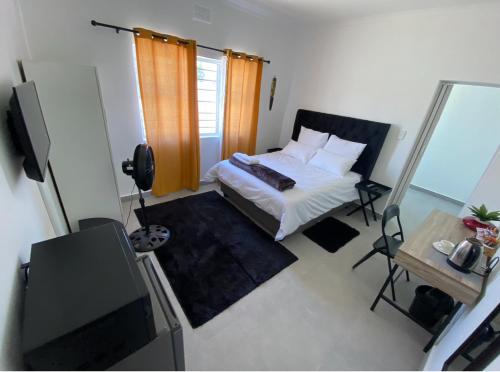 a small bedroom with a bed and a television at No 1 Guest house in Cape Town