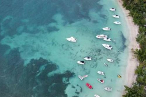 a group of boats in the water on a beach at The Red Door Beach House, Buye Beach in Cabo Rojo