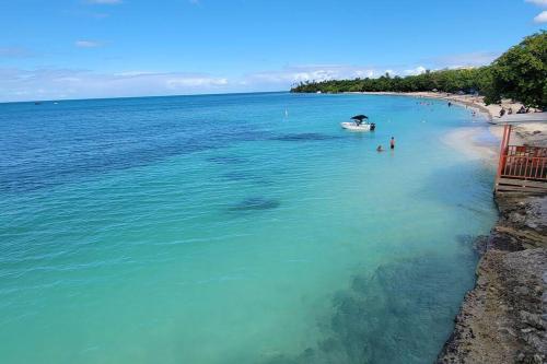 an aerial view of a beach with a boat in the water at The Red Door Beach House, Buye Beach in Cabo Rojo