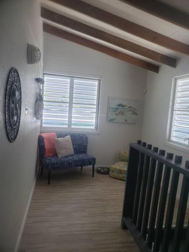 a living room with a couch and two windows at The Red Door Beach House, Buye Beach in Cabo Rojo